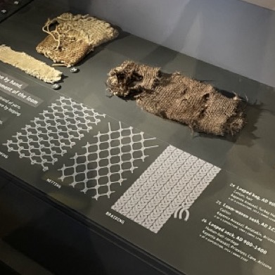 A photo of a museum exhibit showing ancient textiles.